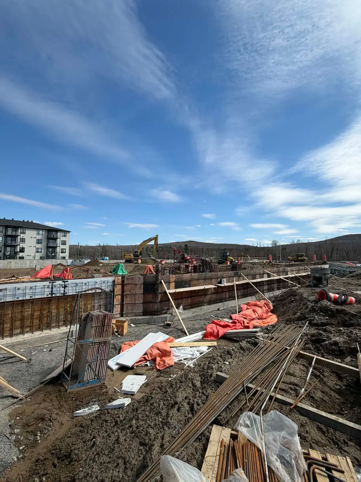 Chantier de fondations avec coffrages et machinerie lourde